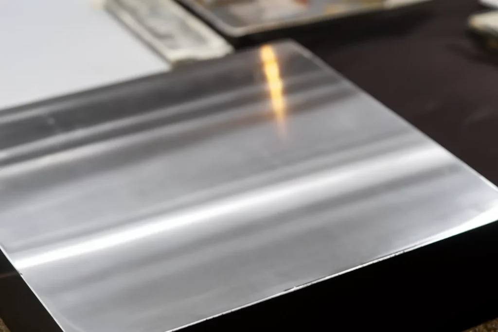 Ein Stück einer Aluminumplatte auf einem Tisch zur Weiterverarbeitung